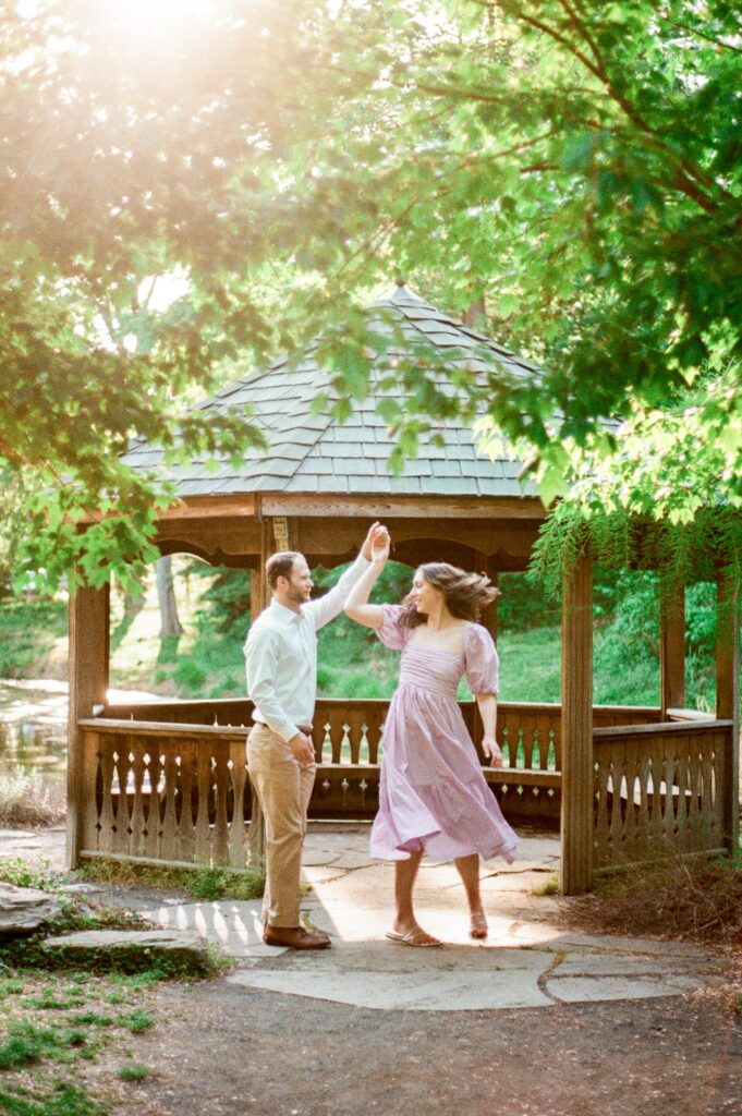 An engaged couple shares a twirl on film