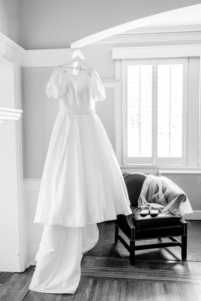A wedding dress hanging in the corner by a window before a Union Street Public House wedding