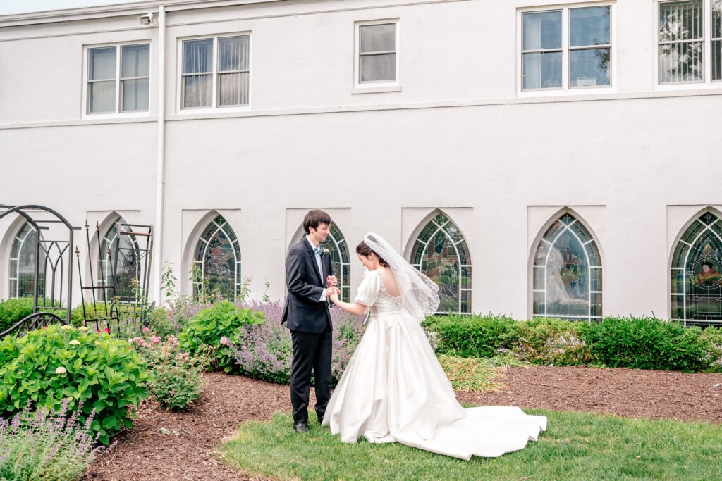 A bride and groom's first look beside the chapel during their Marymount University wedding