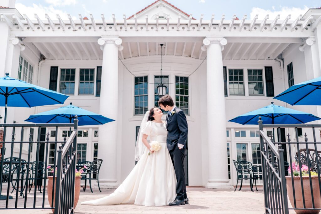 A bride and groom gaze lovingly at one another in front of the Main House