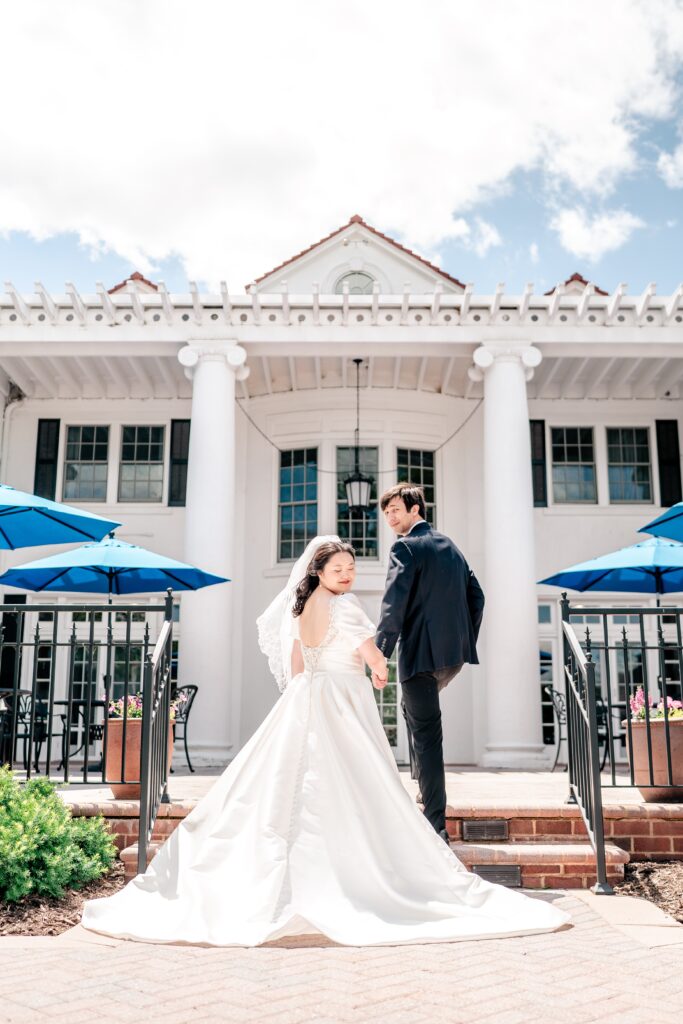 A bride and groom pose on the back patio of the Main House during their Marymount University wedding
