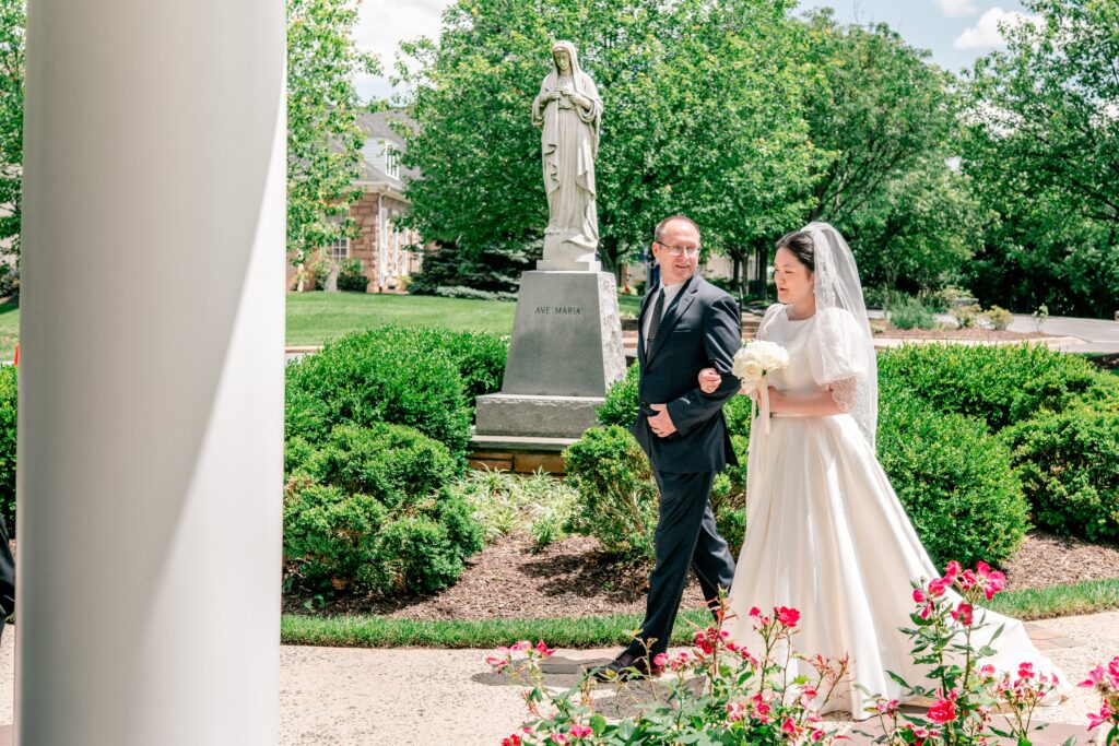 A bride and her father walking into the chapel by Northern Virginia wedding photographer