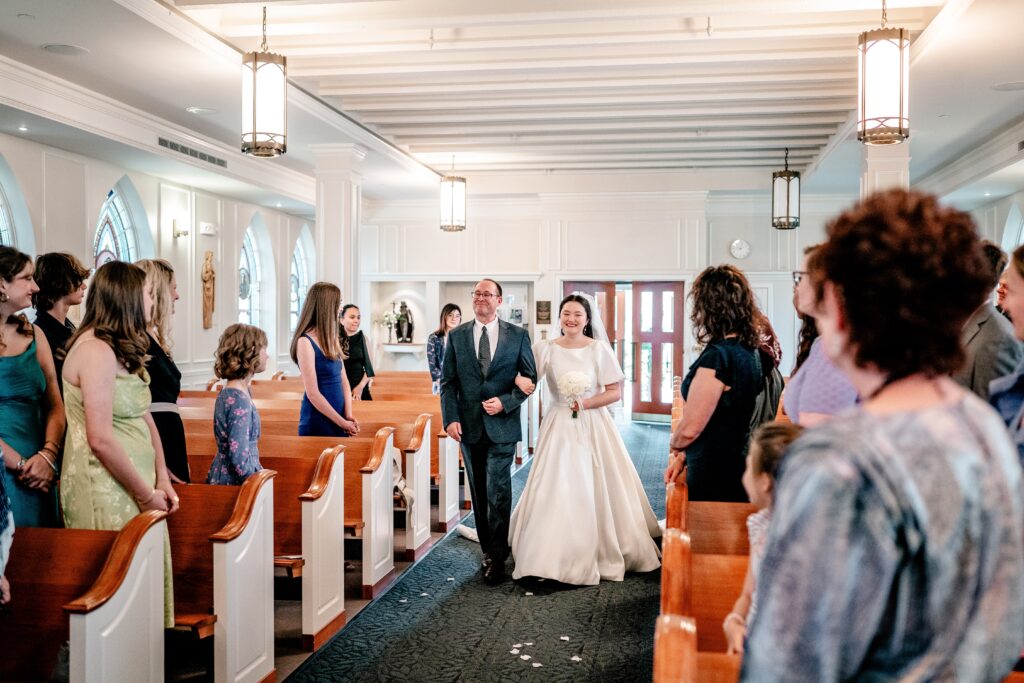 A bride and her father walking down the aisle for a Marymount University wedding