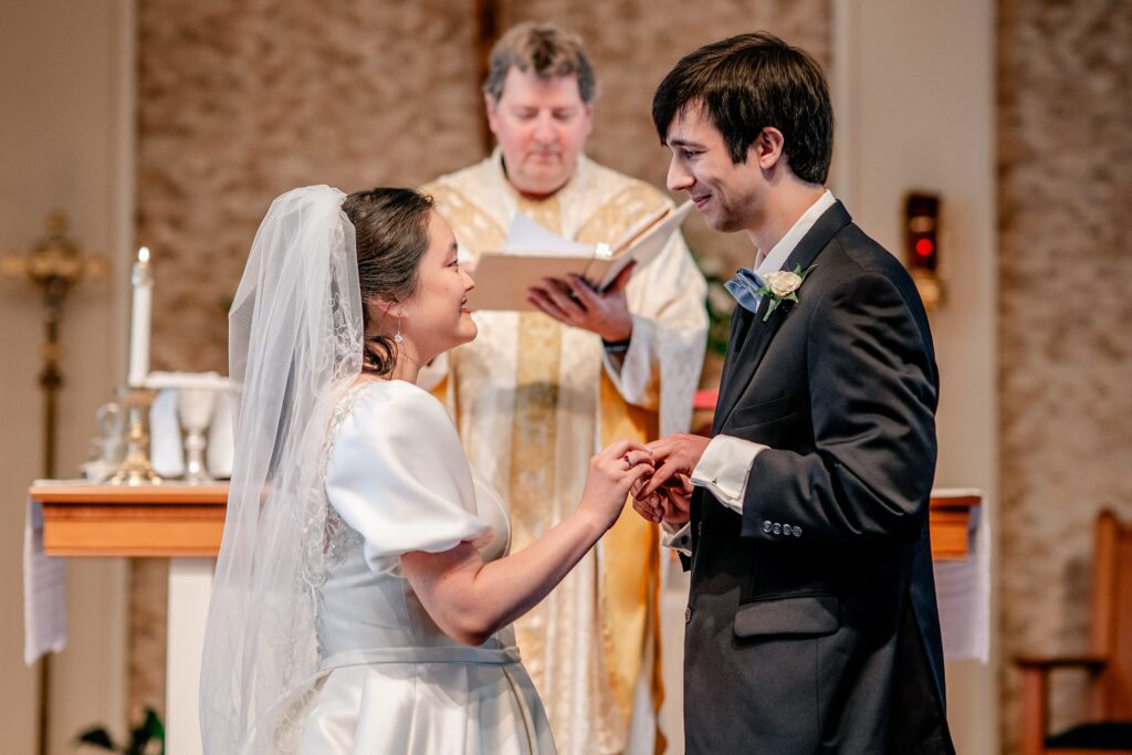 A bride and groom exchanging rings during their Marymount University wedding