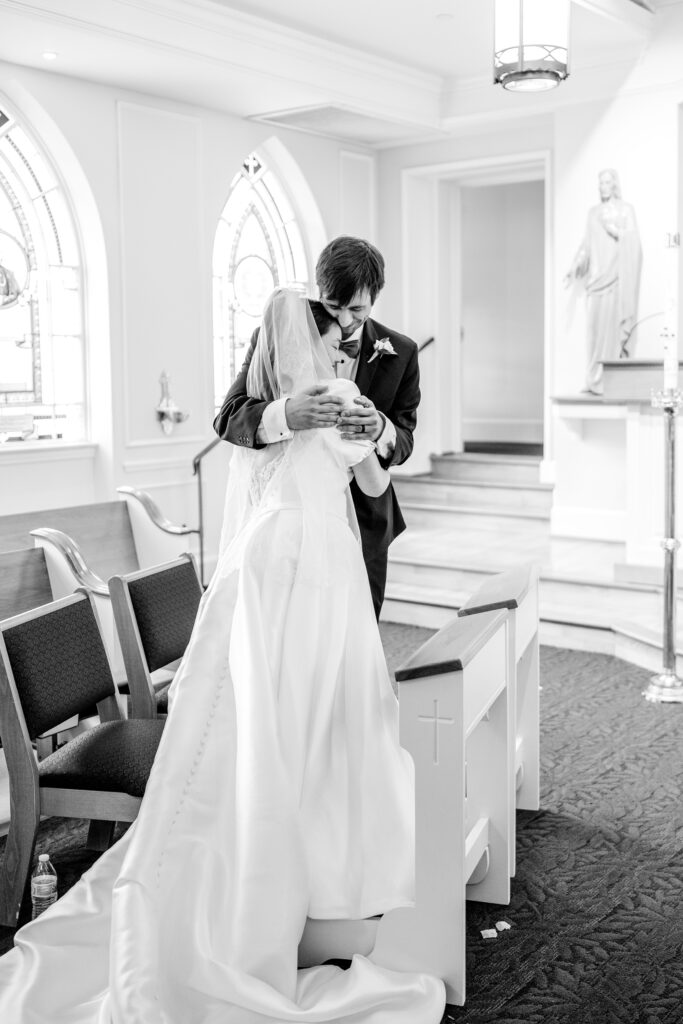 A bride and groom share a hug in the middle of their ceremony by Northern Virginia wedding photographer