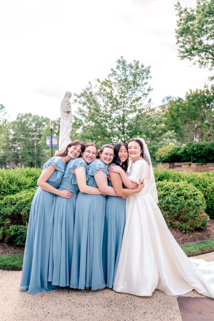 A group of bridesmaids hugging closely in a sweet group portrait by Northern Virginia wedding photographer