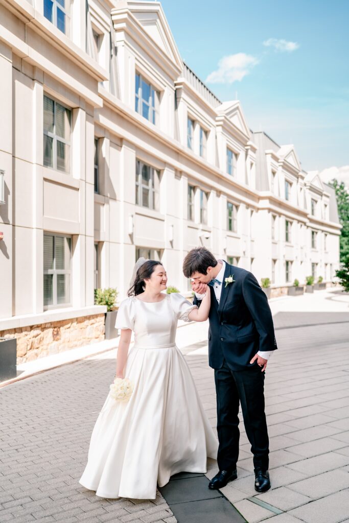 A groom kisses his bride on the hand