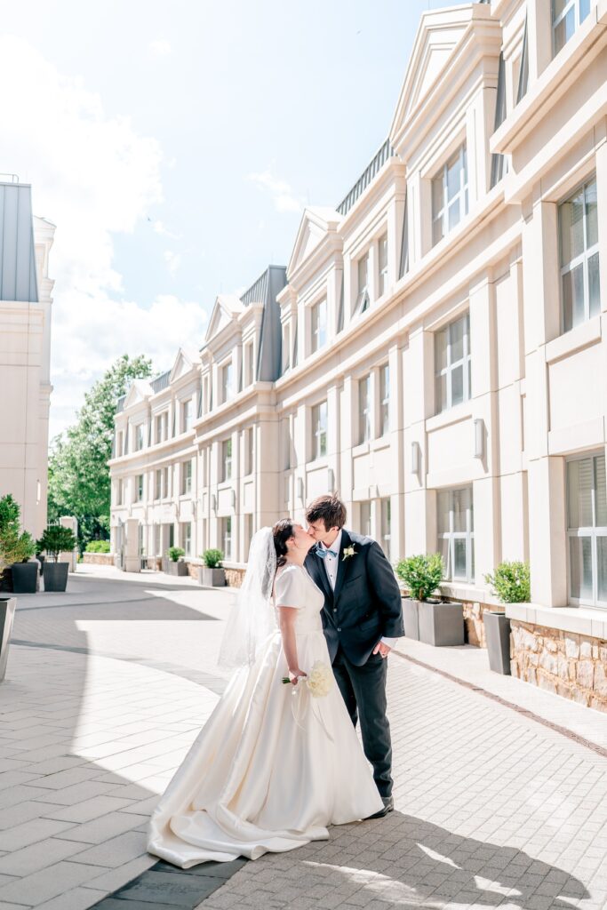 A bride and groom share a kiss in a classic portrait by Northern Virginia wedding photographer