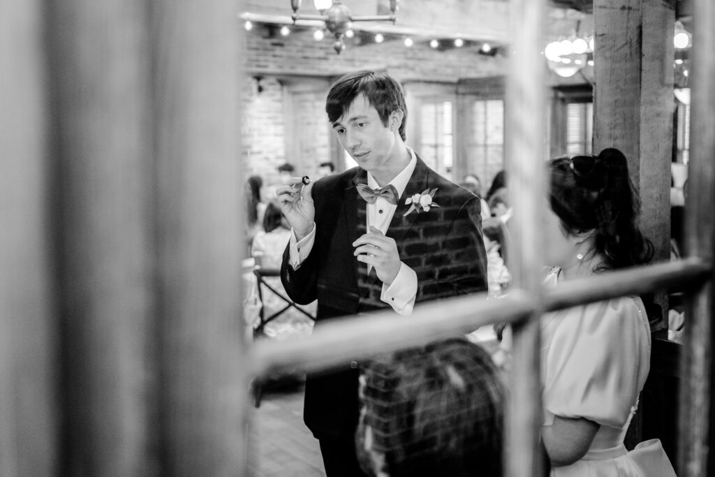 A groom holding up his ring while talking to guests during his Union Street Public House wedding
