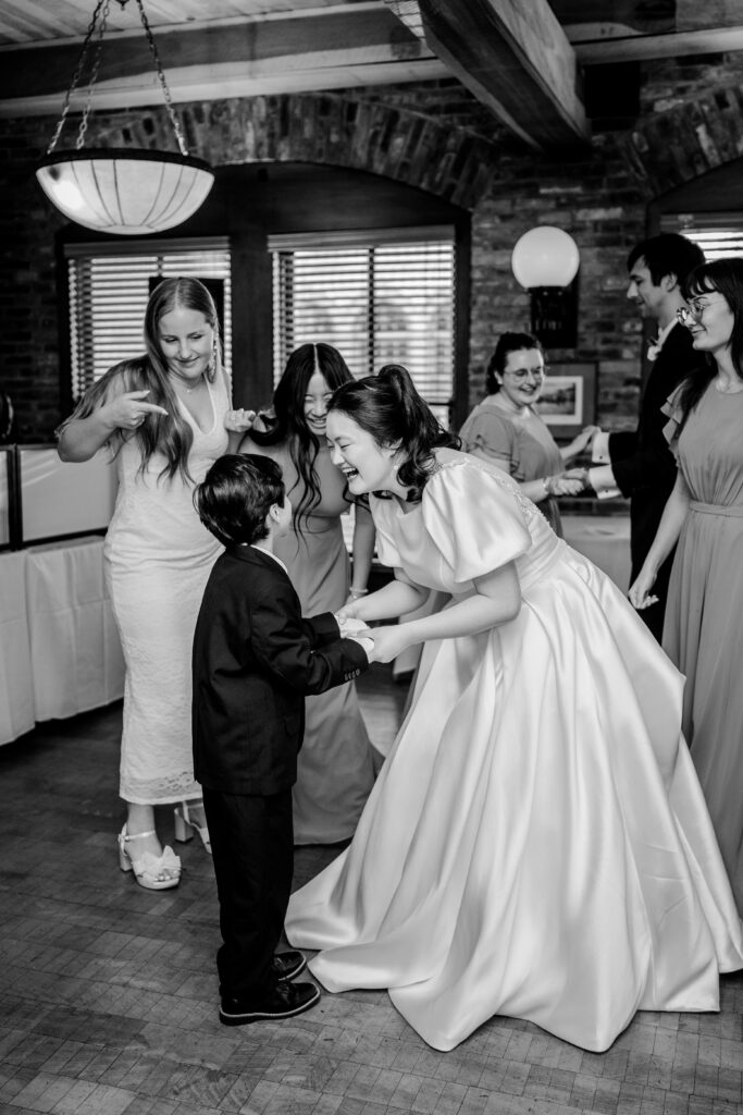 A bride smiling at a young boy on the dance floor during her Union Street Public House wedding