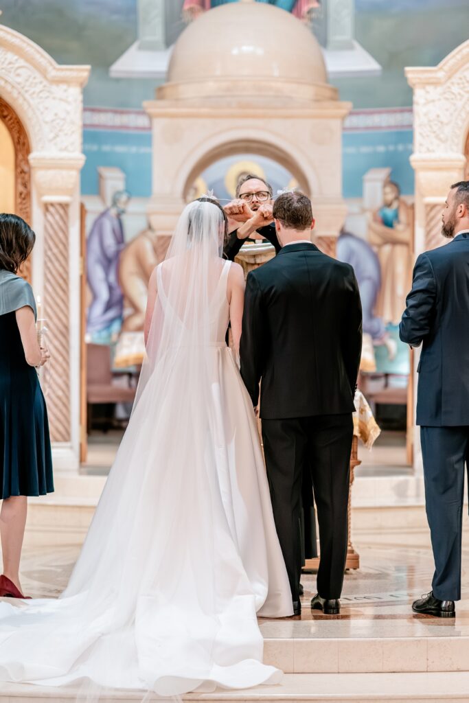 A bride and groom being crowned during their Greek Orthodox wedding
