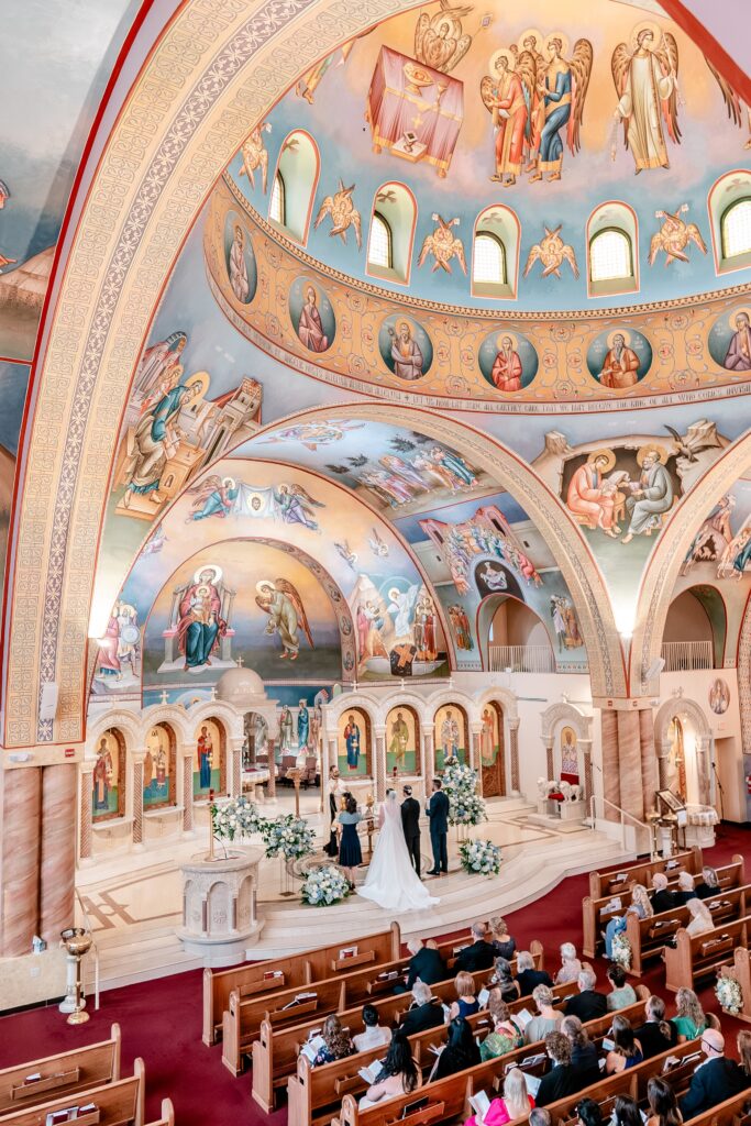 A view of a wedding ceremony from the choir loft by a colorful wedding photographer