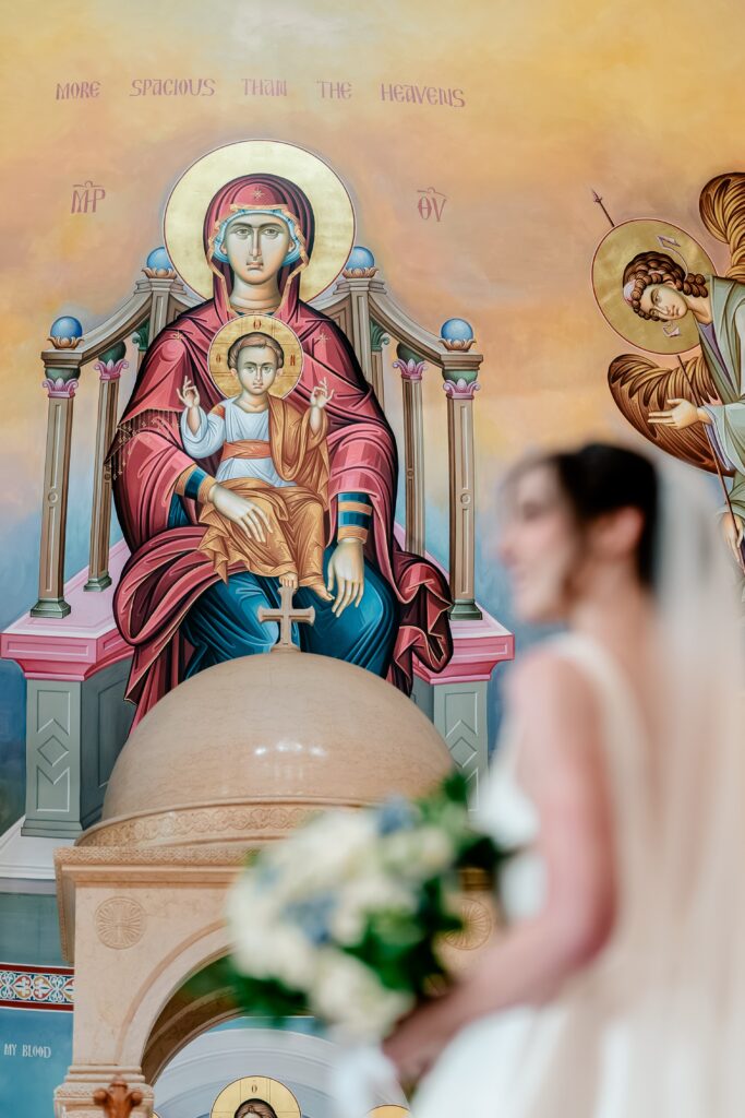 An image of the Blessed Mother with a bride in the foreground during a Greek Orthodox wedding