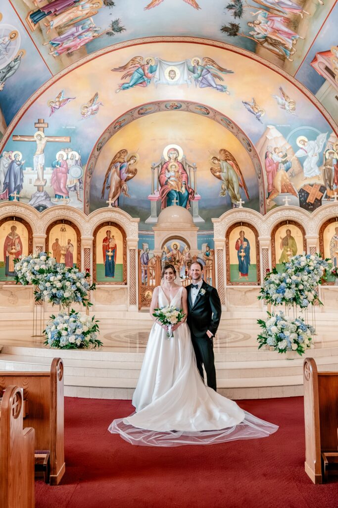 A bride and groom posing for a classic portrait during their Greek Orthodox wedding