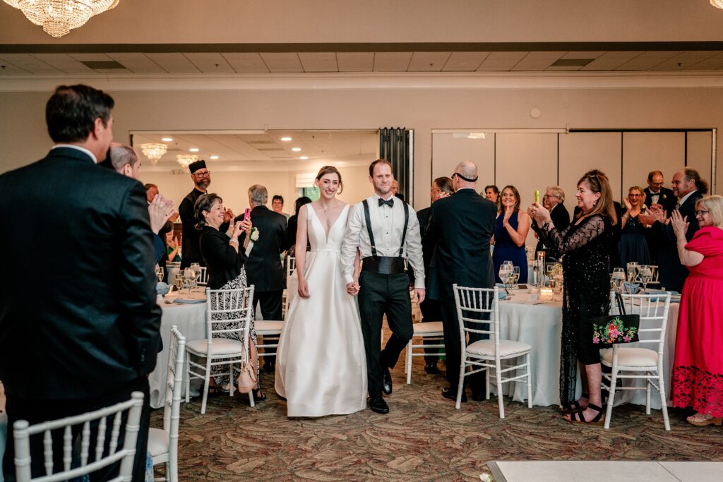 A bride and groom walking into their wedding reception together