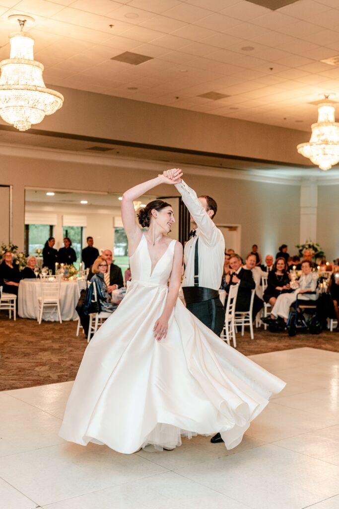 A bride twirling during her first dance with her new husband by a colorful wedding photographer