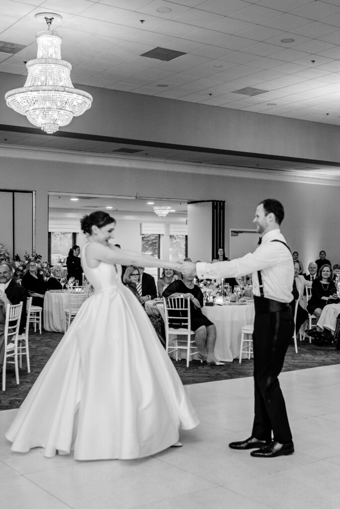 A bride and groom holding hands during their first dance