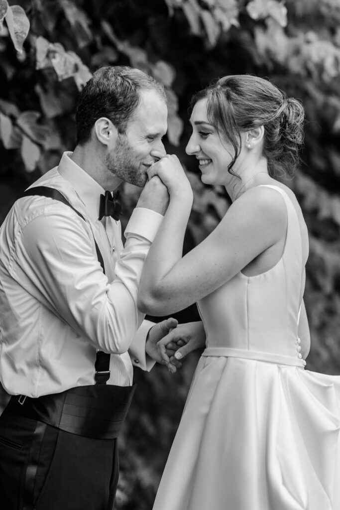 A groom kissing the hand of his bride in a portrait by a colorful wedding photographer
