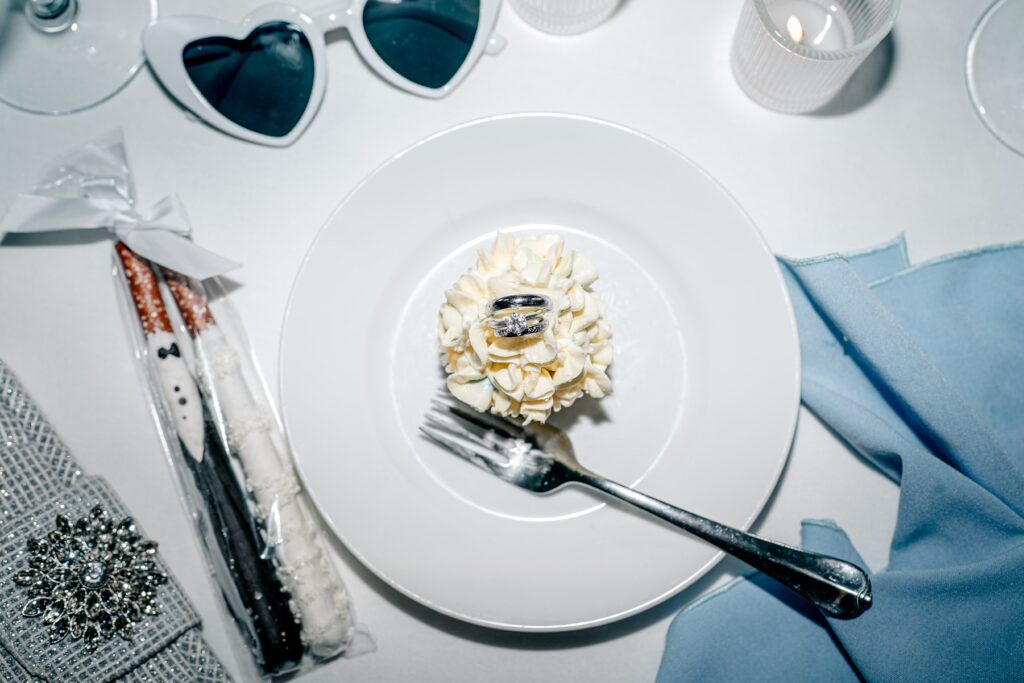 A cupcake with wedding rings placed in the center