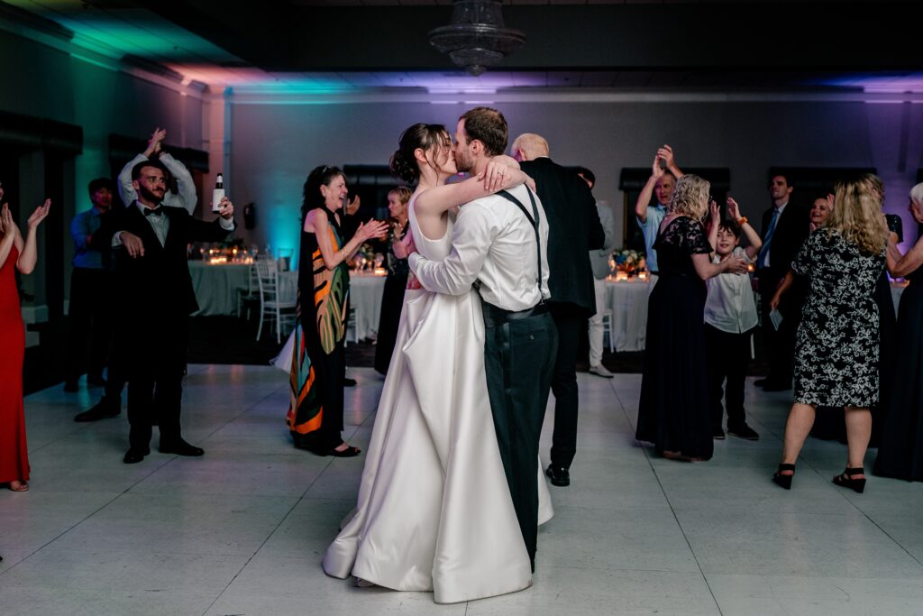 A bride and groom sharing a kiss on the dance floor of their reception