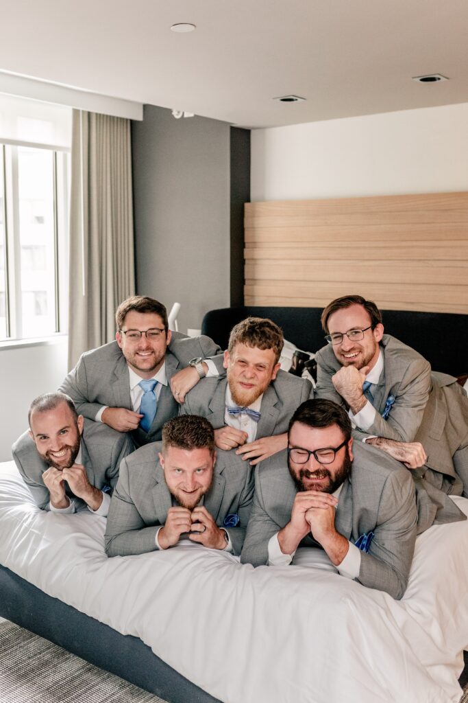Groomsmen posing together in the hotel room before an Immaculate Conception Church wedding