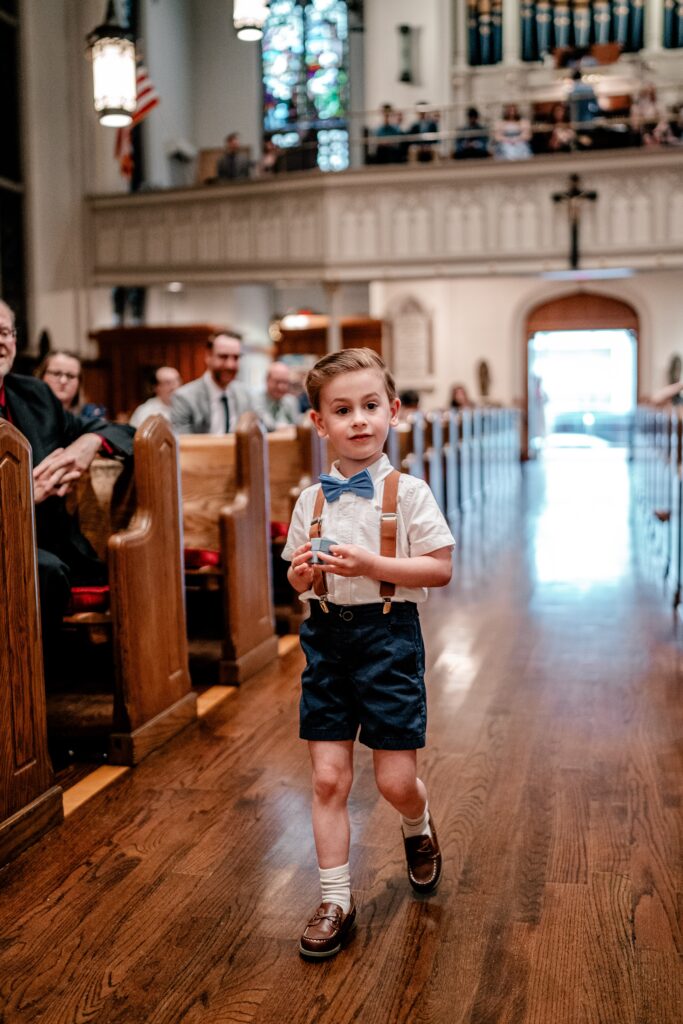 A ring bearer bringing up the rings during a wedding ceremony in a Catholic church