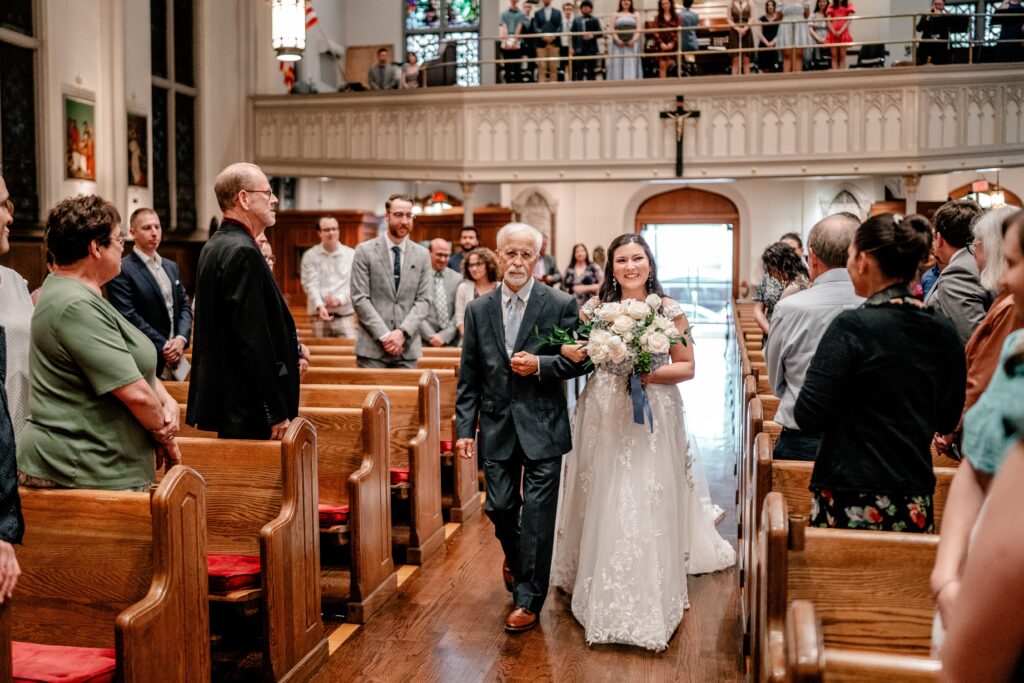 A bride walking down the aisle with her dad toward her Washington DC wedding photographer