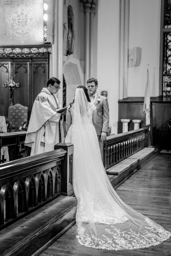 A bride's long train draping down as she and her husband standing at the altar for their vows