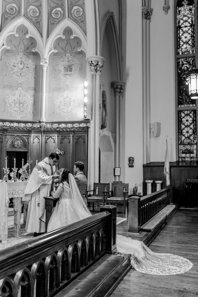 A bride receiving Communion by a Washington DC wedding photographer