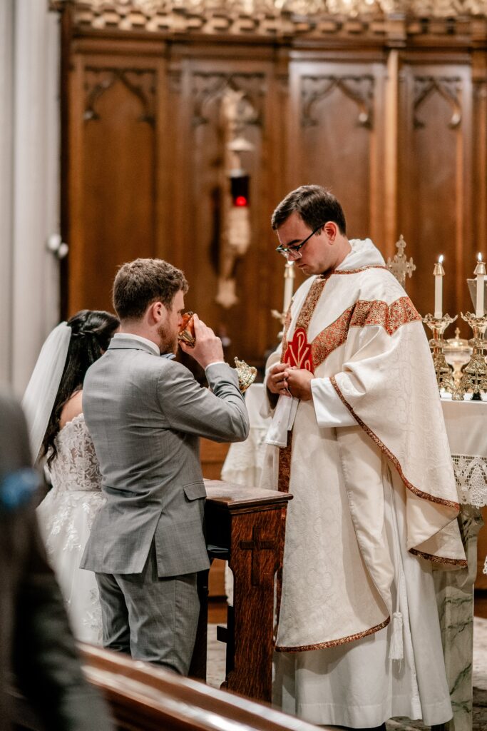 A groom receiving Communion during his wedding