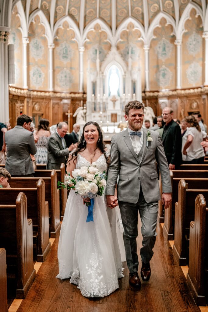 A bride and groom recessing down the aisle toward their Washington DC wedding photographer