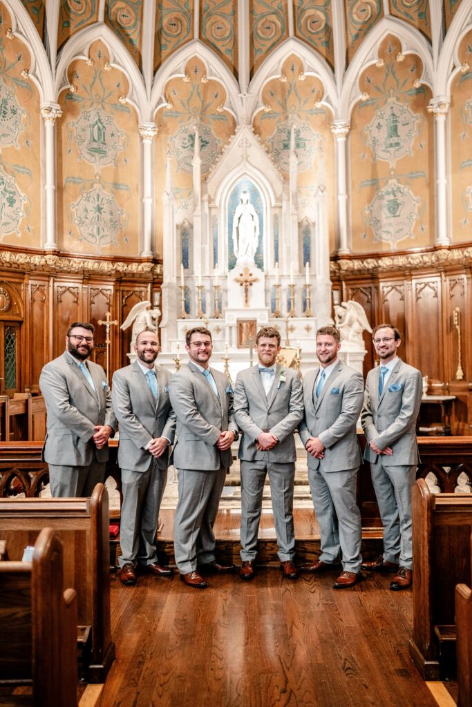 A group of groomsmen posing by the altar after an Immaculate Conception Church wedding