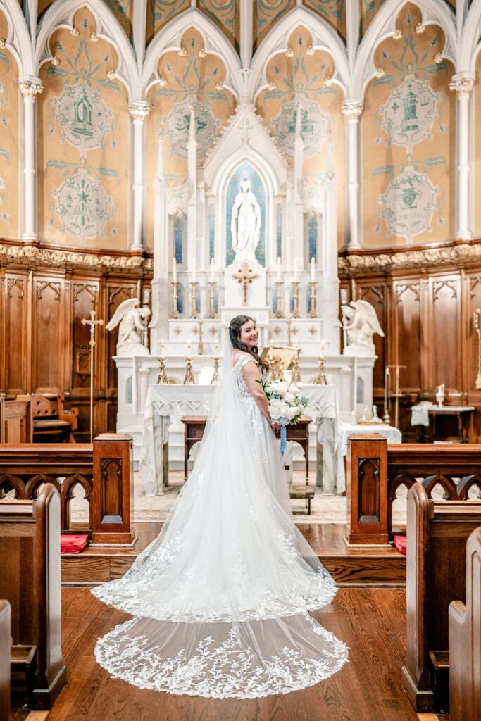 A bride showing off her train after her Immaculate Conception Church wedding