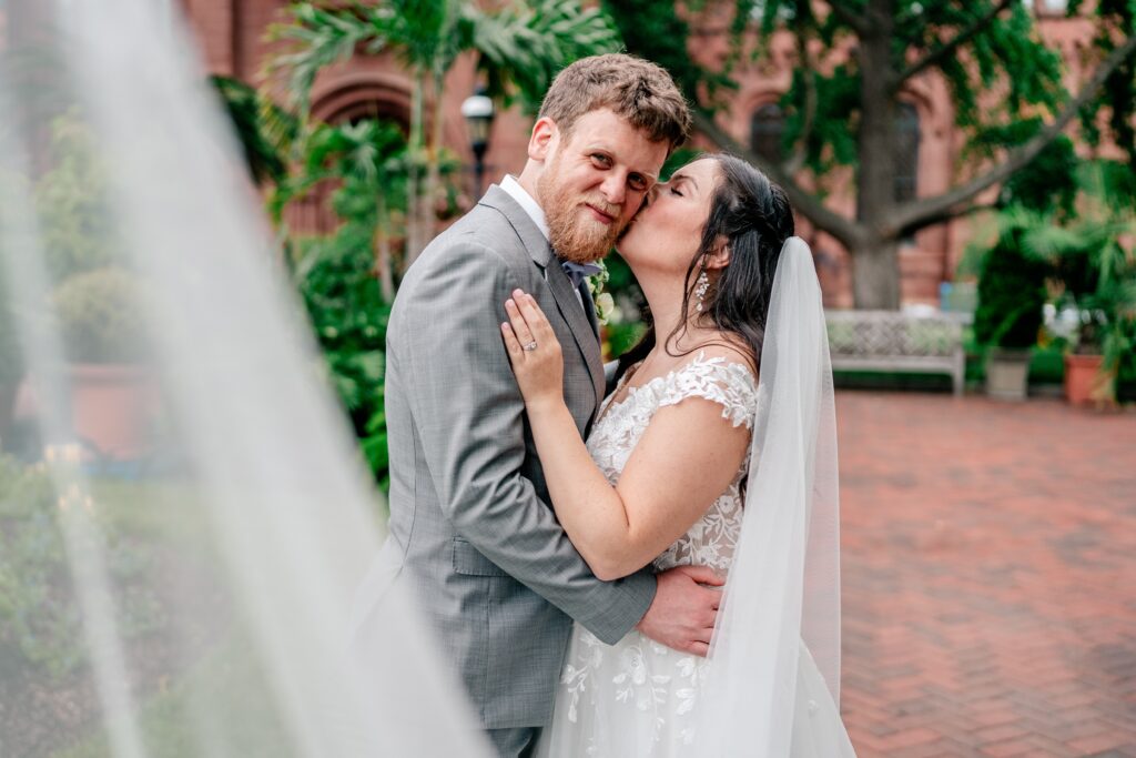 A bride kissing her groom on the cheek for her Washington DC wedding photographer