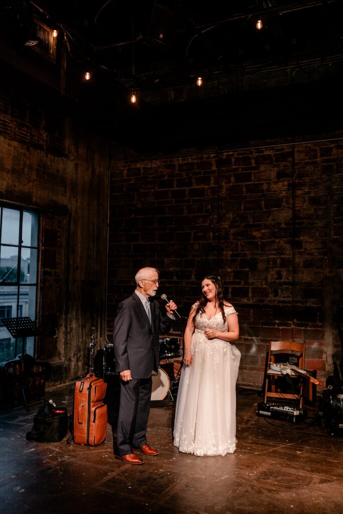 A bride and her father singing a duet together after her Immaculate Conception Church wedding