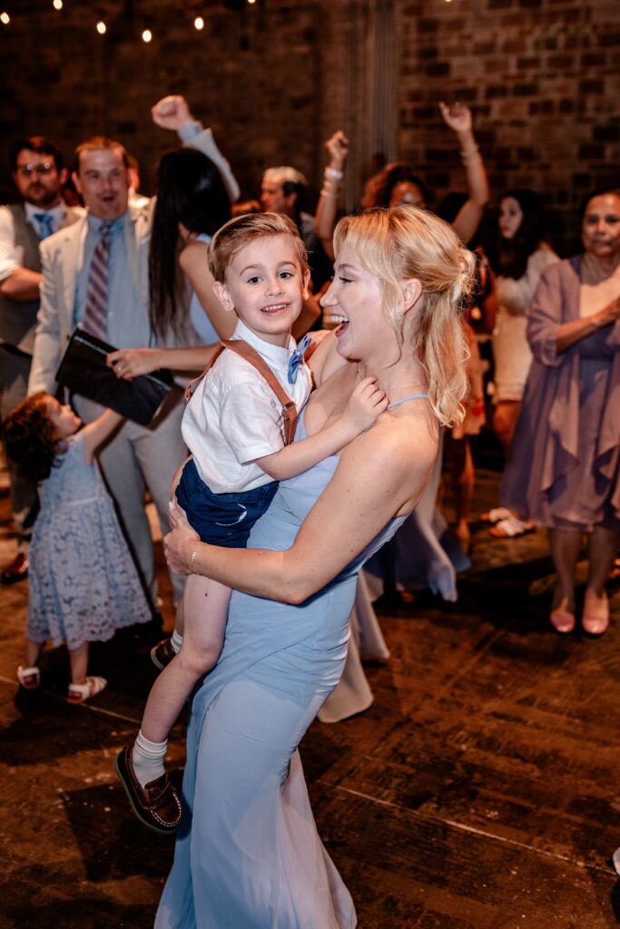 A bridesmaid dancing with the ring bearer for the Catholic wedding photographer