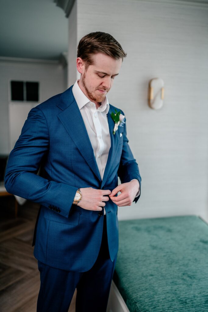 A groom putting on his suit before his Atrium at Meadowlark wedding