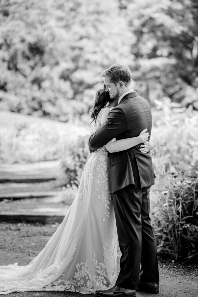A bride and groom embrace during their first look
