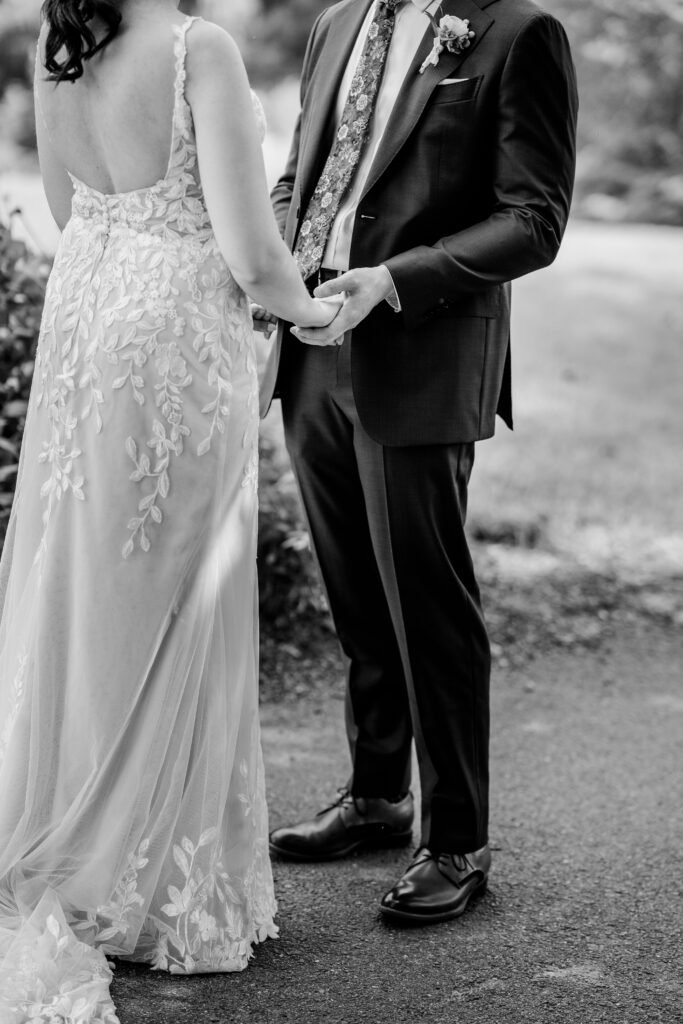 A bride and groom holding hands during their First Look by a Northern Virginia wedding photographer