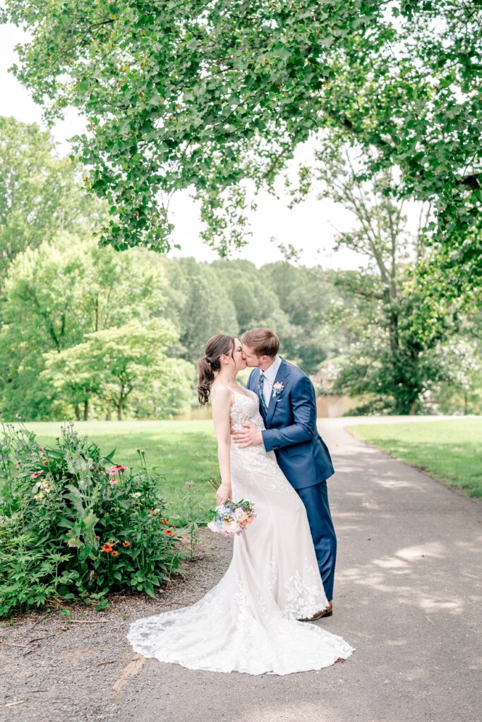 A bride and groom share a kiss in the gardens during an Atrium at Meadowlark wedding