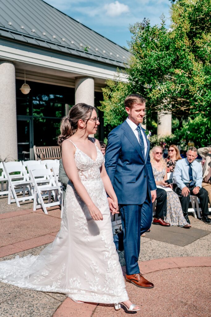 A bride and groom walk into their ceremony together during their Meadowlark Botanical Gardens wedding