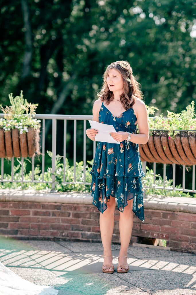 A bridesmaid reading during a ceremony by a Northern Virginia wedding photographer