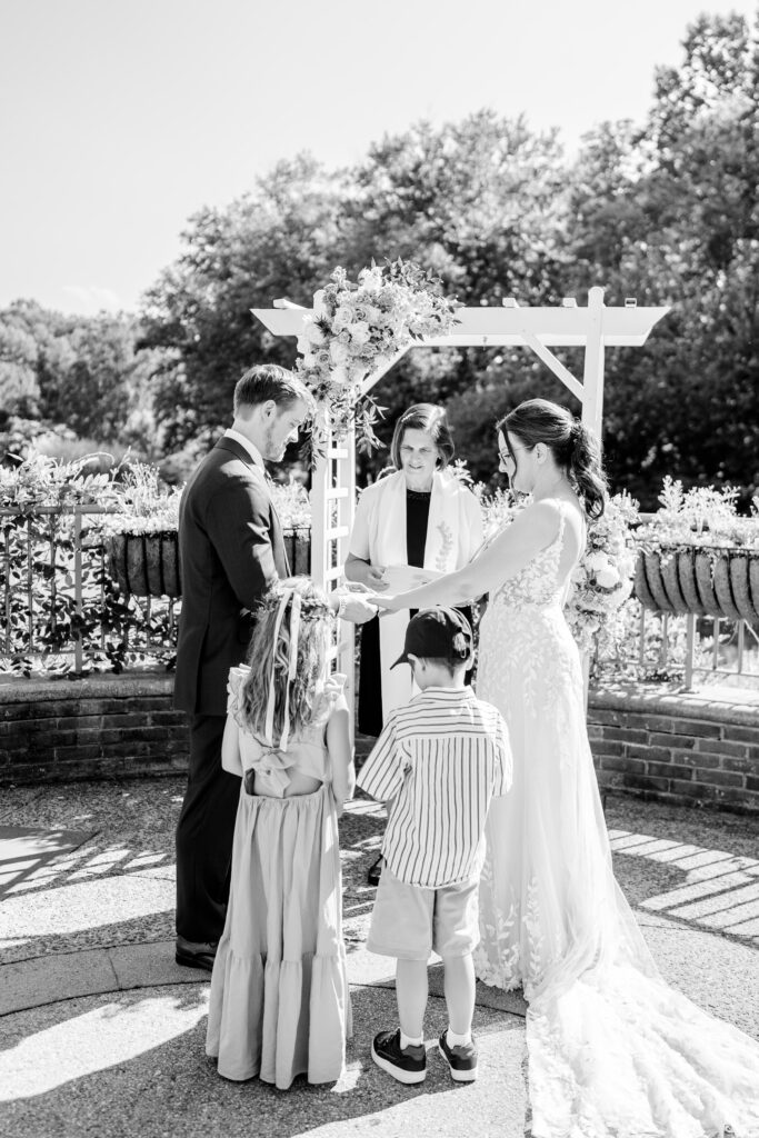 A bride and groom exchange rings during their Atrium at Meadowlark wedding