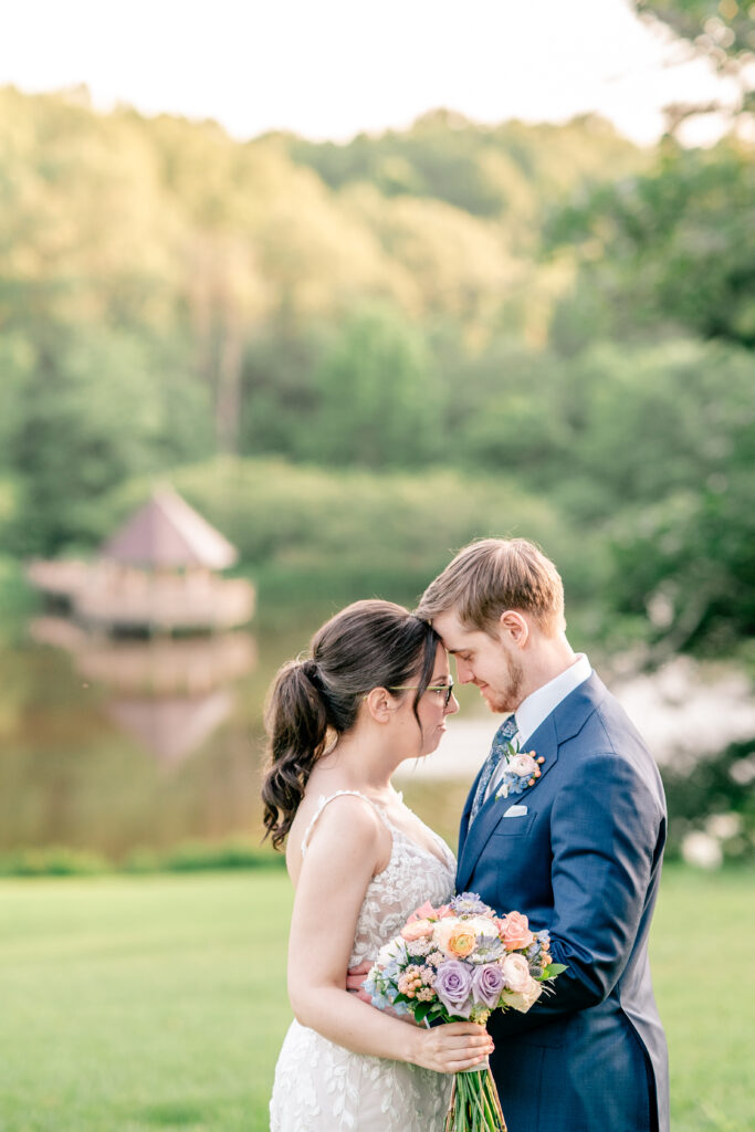 A bride and groom standing forehead to forehead during golden hour