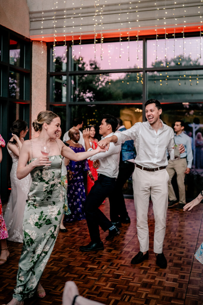 Wedding guests laughing and dancing together