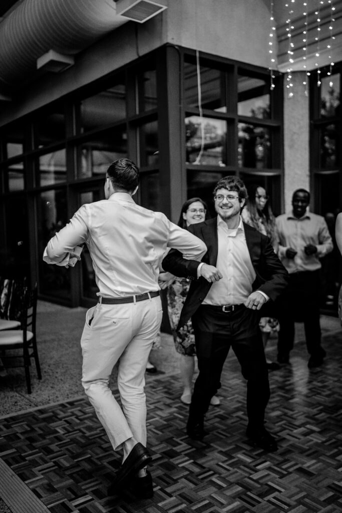 Wedding guests dancing together in candid photos by a Northern Virginia wedding photographer