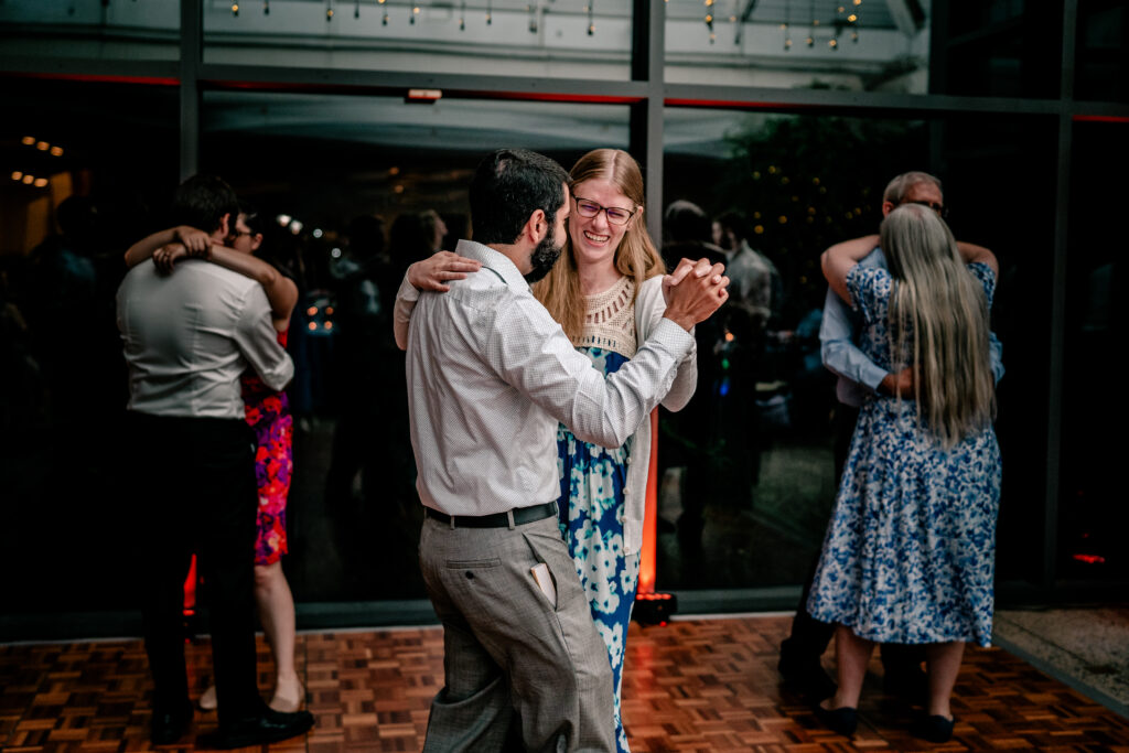 Wedding guests laughing and dancing together during a Meadowlark Botanical Gardens wedding