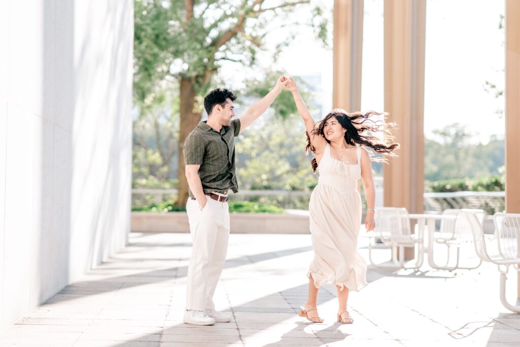 A couple twirling outside together during their Kennedy Center engagement photos