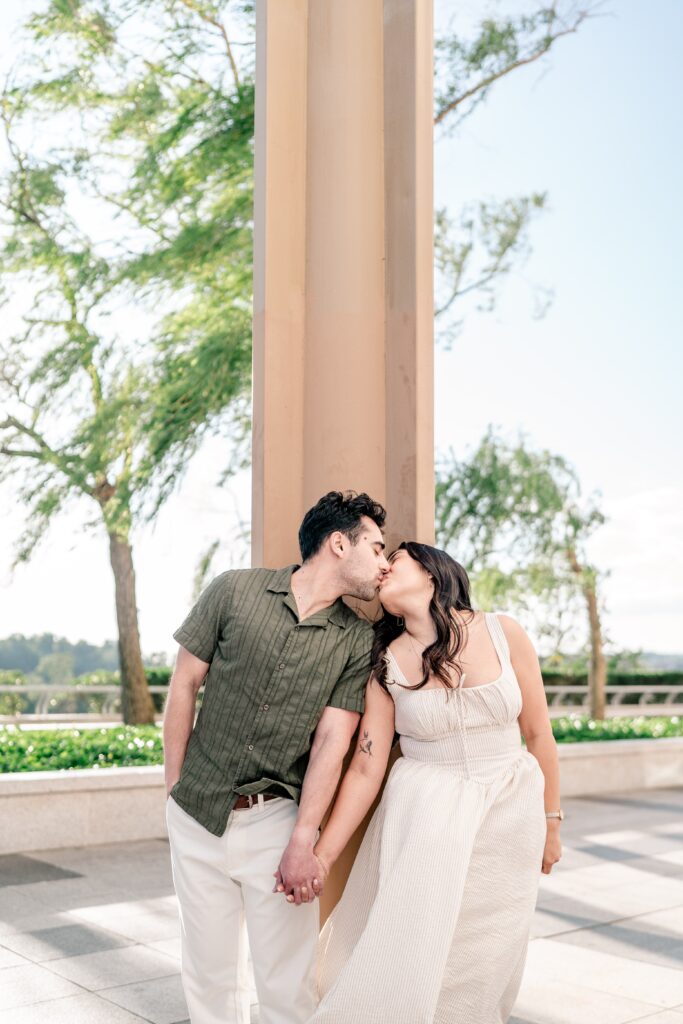 A couple sharing a kiss in front of a column at one of the best places to take engagement photos in DC
