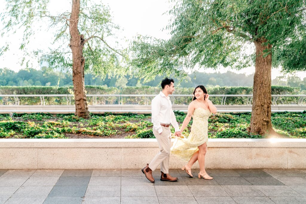 A couple walking together across the terrace during their Kennedy Center engagement photos